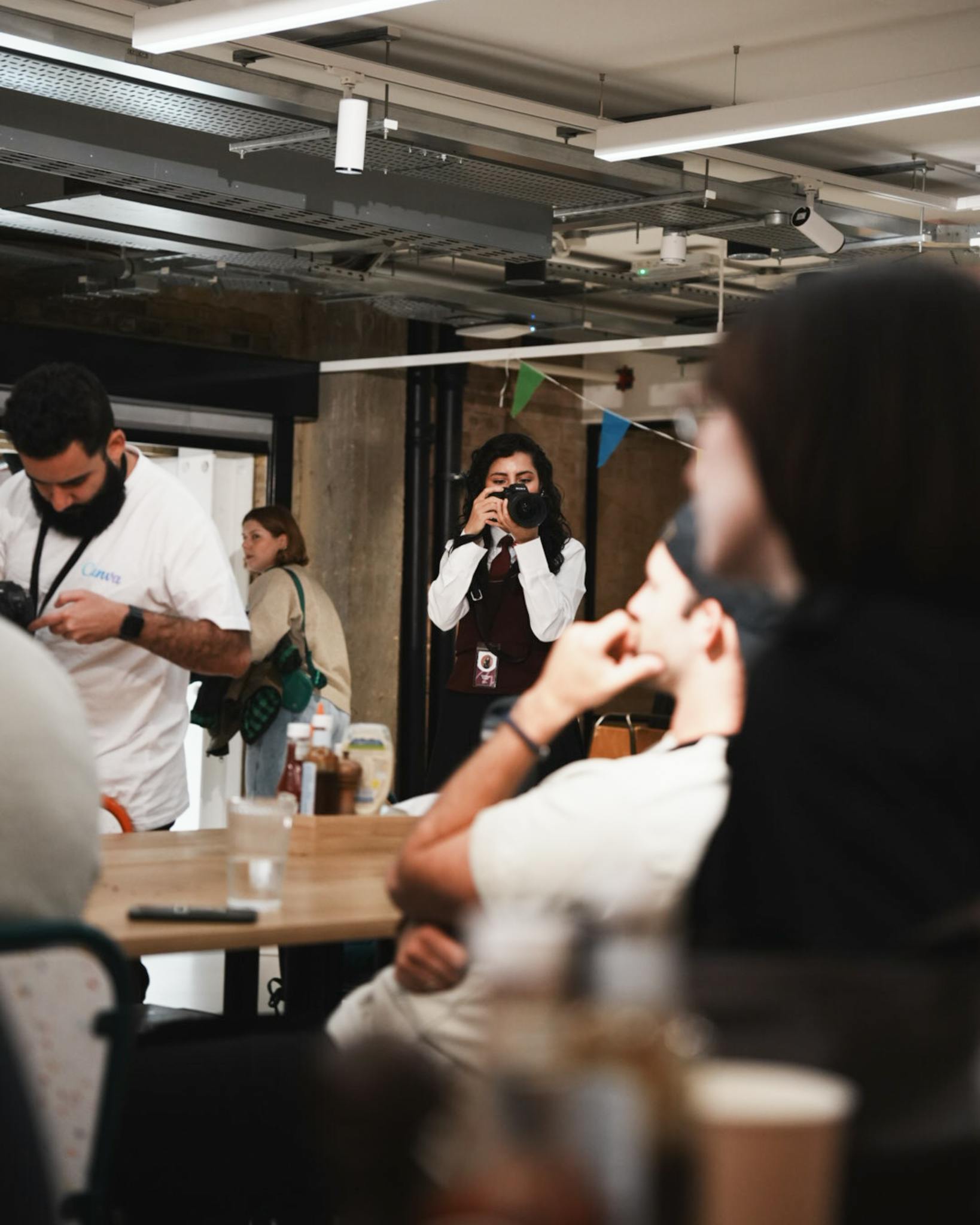 A candid indoor scene capturing a photographer at a casual gathering.